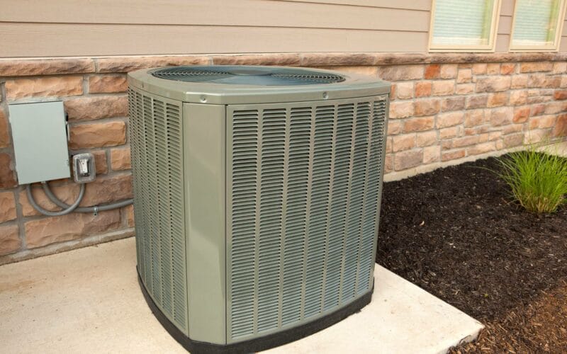Outdoor central air conditioning unit installed beside a home