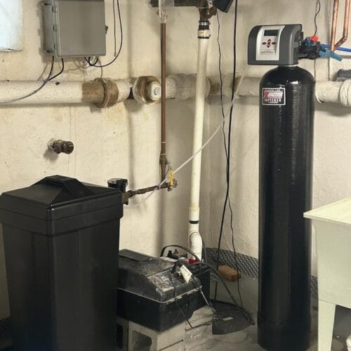 Water softener system with brine tank installed in basement