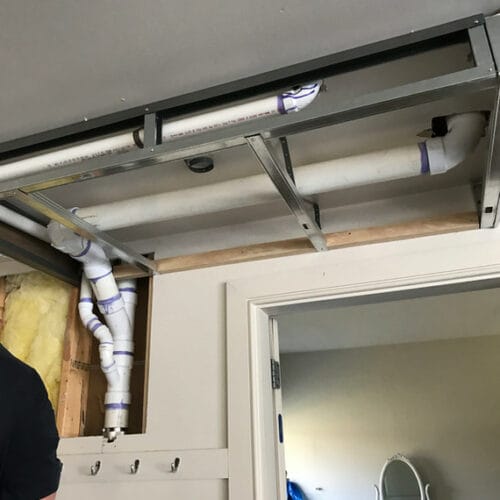 PVC plumbing lines installed above a doorway with open framing