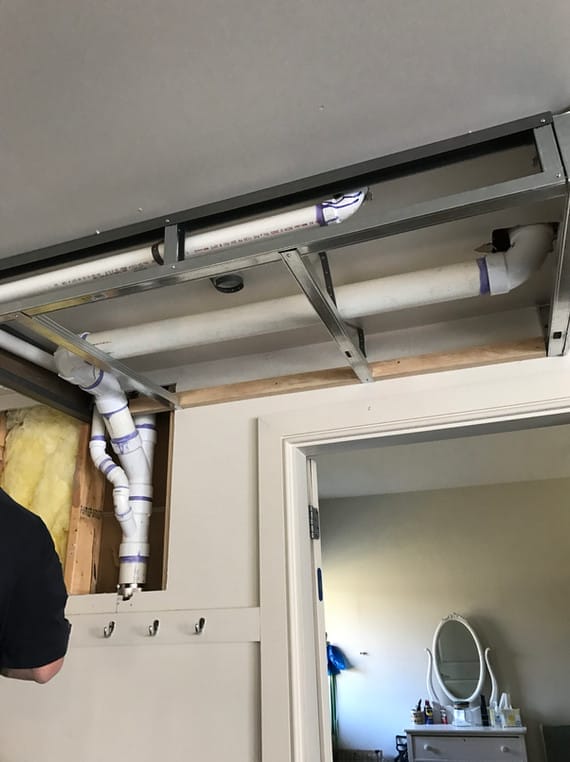 PVC plumbing lines installed above a doorway with open framing