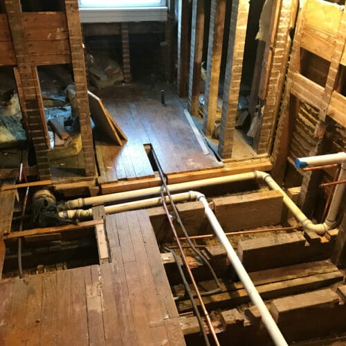 Bathroom renovation with new PVC and copper plumbing installed between joists