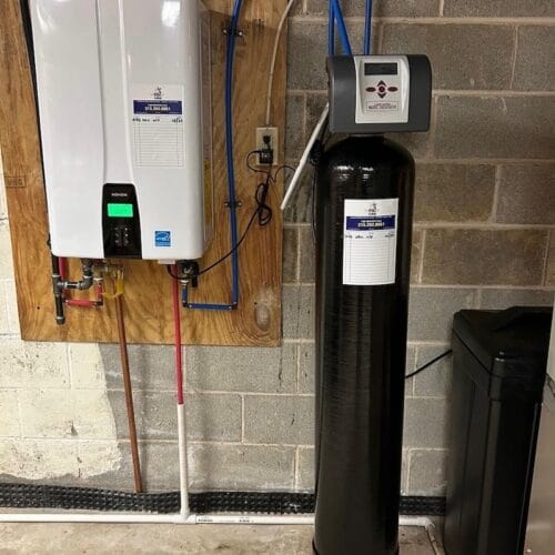 Tankless water heater and whole-house water softener system installed in a basement
