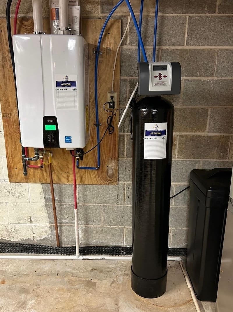 Tankless water heater and whole-house water softener system installed in a basement