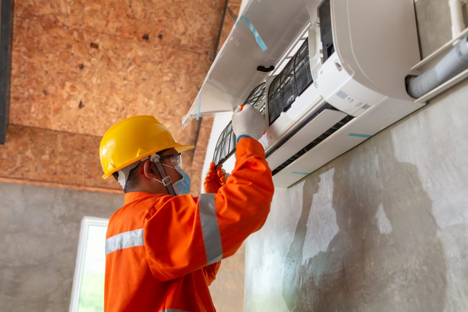 An HVAC technician installing a new air conditioning unit, carefully connecting the components and ensuring the system is set up correctly for efficient cooling.